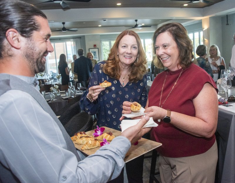 Server David Natrin shares jamon Iberico croissants with dinner guests Sherry Williams-Fried, center, and Annette Stellhorn.